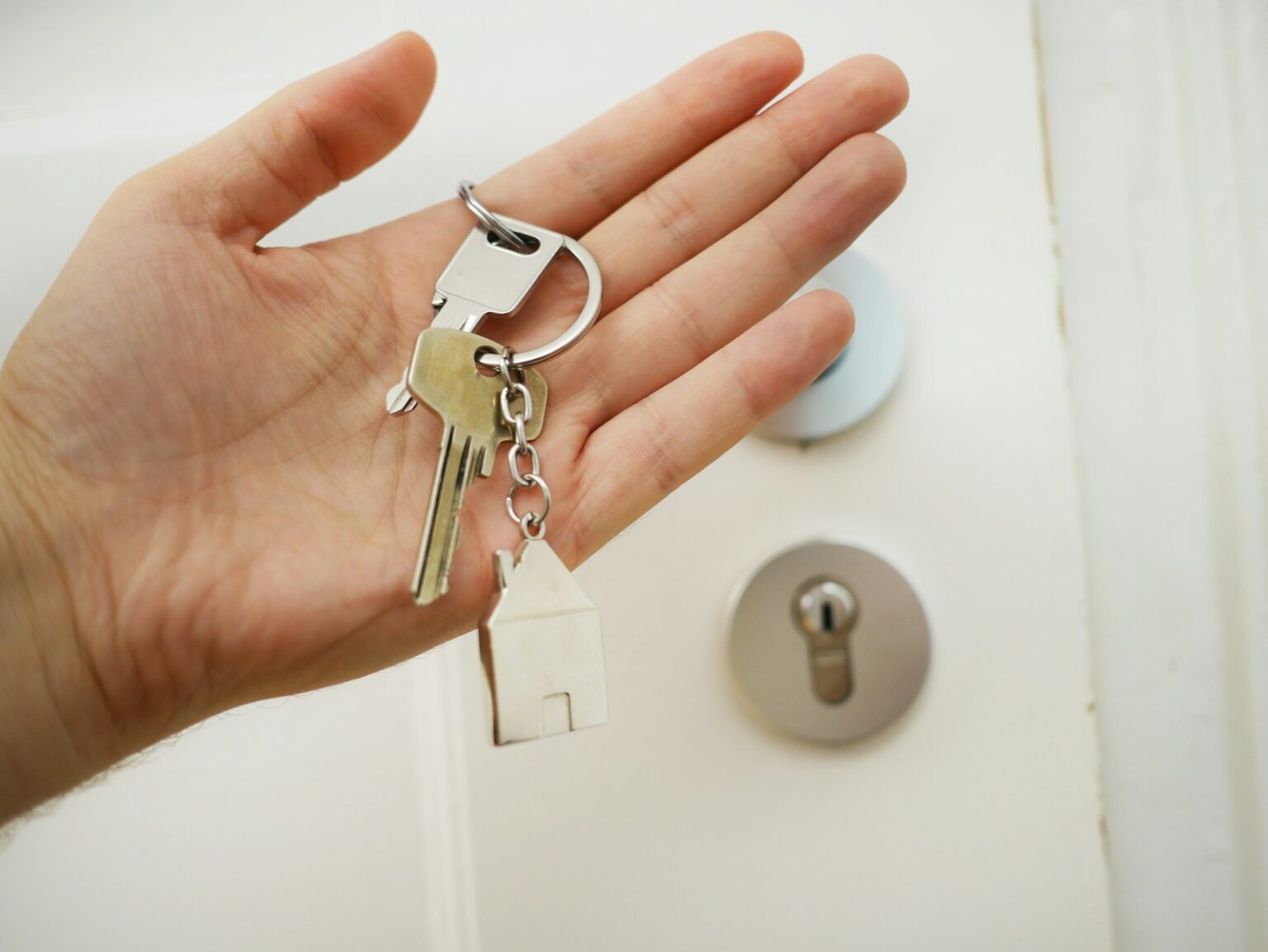 Secure Your Home with Guardian Angel Lock & Security House keys held in front of a door lock