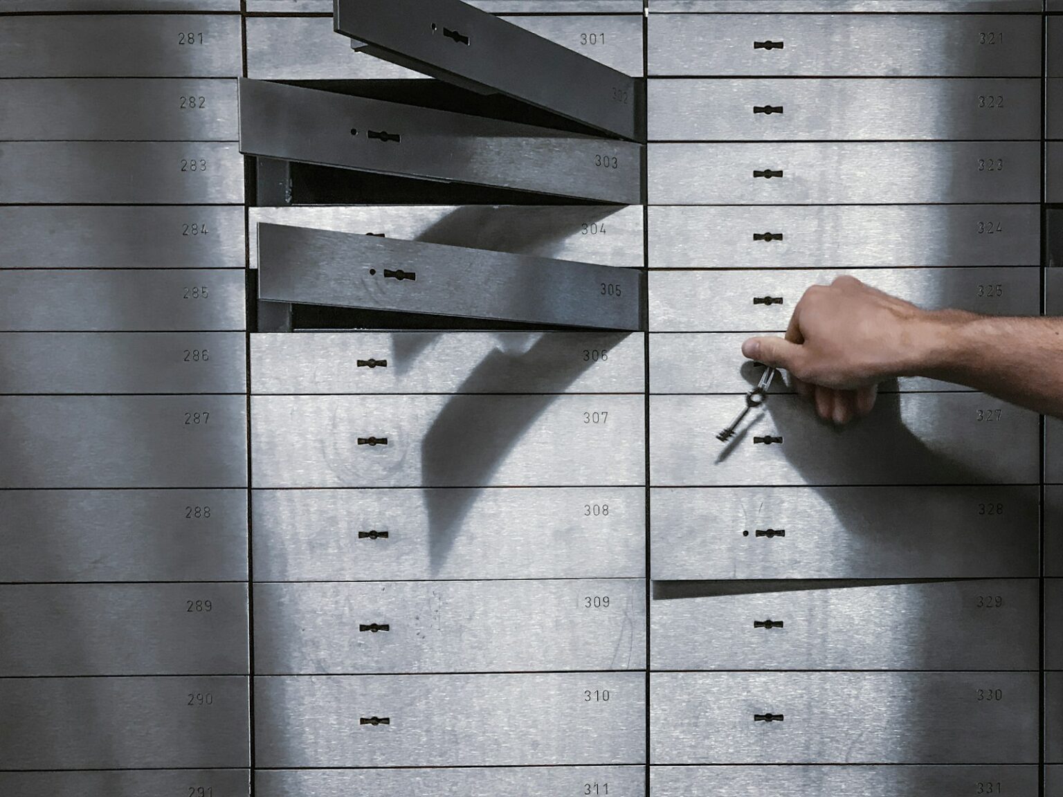Is Your Bank Closing Your Safe Deposit Box? Hand opening a safe deposit box with a key